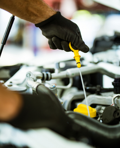 Car mechanic changing oil